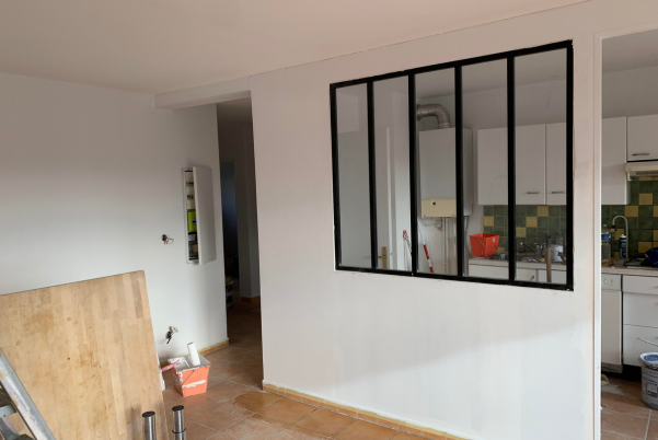 Vue int�rieure apr�s travaux de r�novation et de peinture, montrant une verri�re style atelier pos�e entre le salon et la cuisine par un artisan peintre � Gardanne
